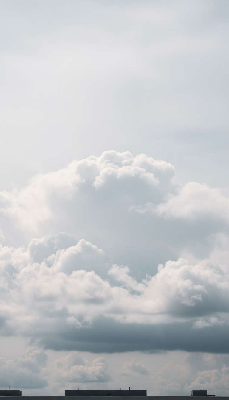 A dramatic formation of sprawling cumulus clouds fills the upper half of a pale, muted sky, their pillowy contours softly gradated from pearl white to gentle dove grey. Below, a minimalist, nearly featureless skyline accentuates the sky’s dominance. The entire scene is illuminated by diffused overcast light, even and soft, which brings out the subtle volume and depth within each cloud. The atmosphere is serene and contemplative, inviting quiet observation. Captured from an eye-level perspective using photographic realism, the composition follows a rule of thirds with clouds commanding focus. The refined color palette and minimalist elements convey sophistication, perfectly complementing a site dedicated to elegant cloud photography.
